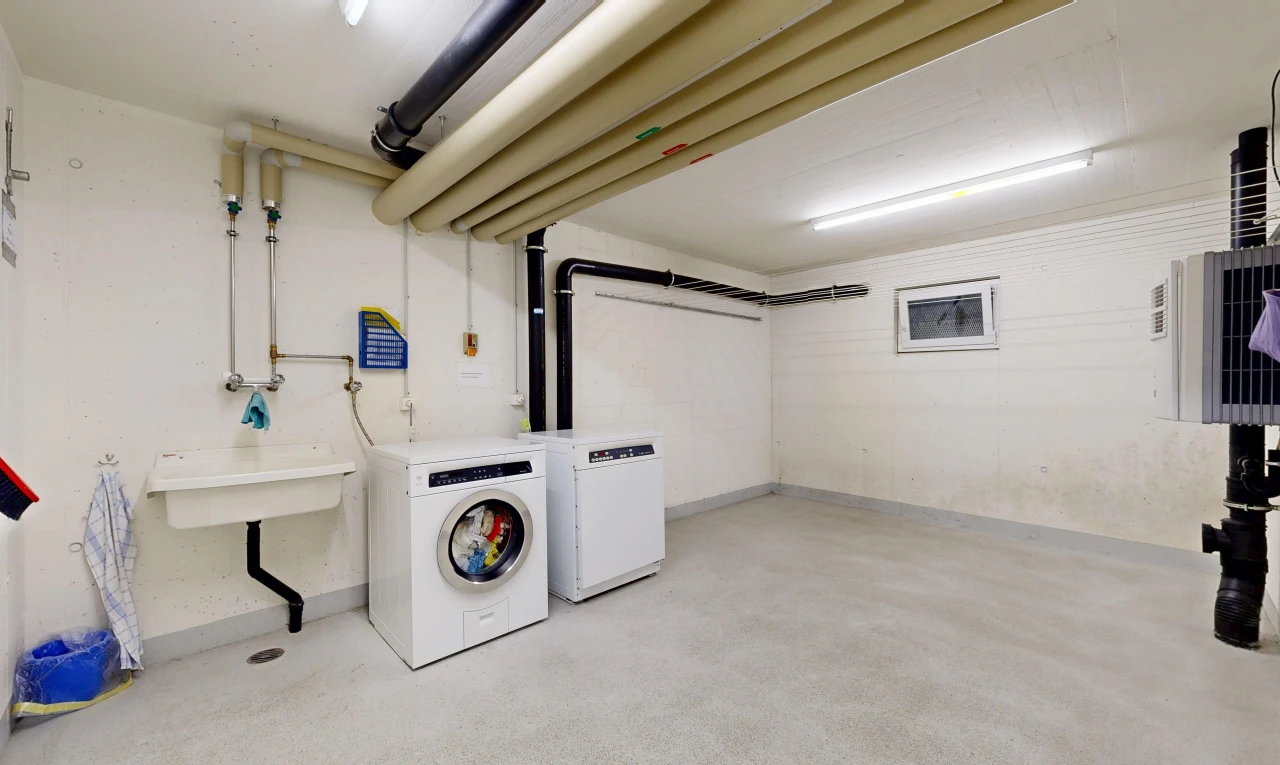 laundry area featuring a sink and concrete flooring