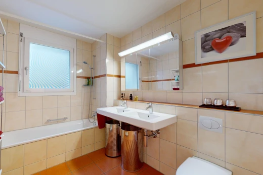 bathroom with tile walls, tiled shower / bath combo, and light tile patterned flooring