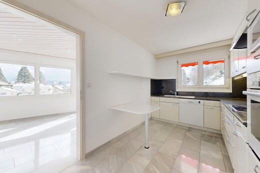 cuisine avec dark countertops, plans de travail, light floor, drywall, et cloison sèche