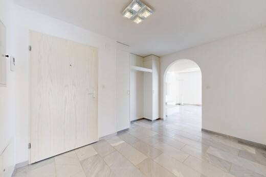 pièce vide avec passages en arc, cloison sèche, drywall, light floor, et inside property