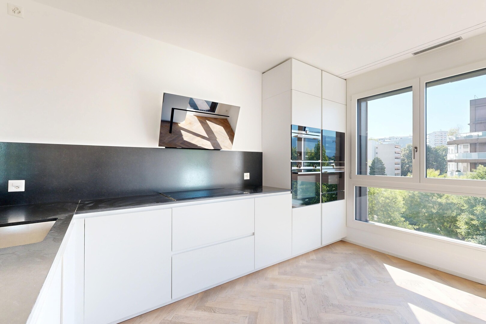 cuisine avec armoires à panneau plat, flat panel cabinets, inside property, parquet floor, et light floor