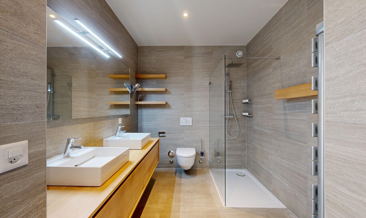 salle de bains avec mur en carrelage, tile wall, douche, double vasque, et salle de bain complète