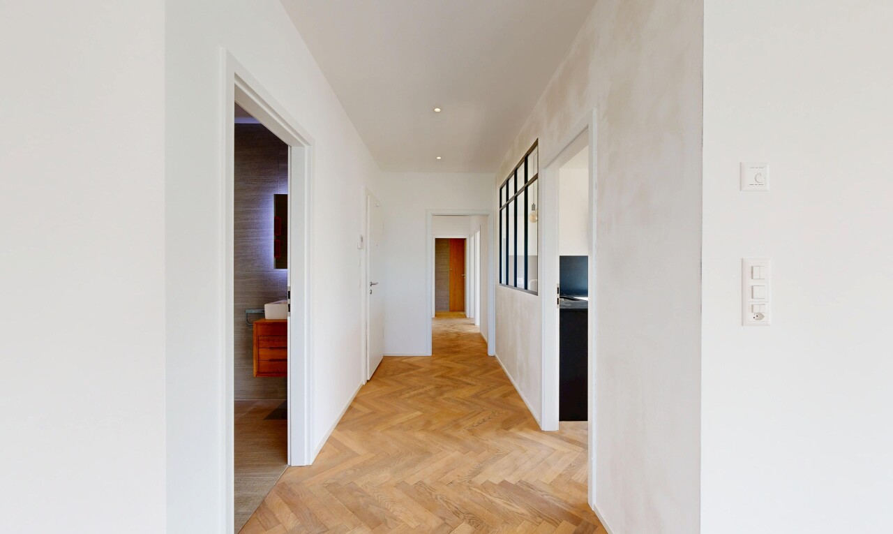 couloir avec parquet floor, cloison sèche, drywall, sol en finition bois, et wood finish floor