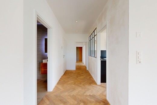 couloir avec parquet floor, cloison sèche, drywall, sol en finition bois, et wood finish floor