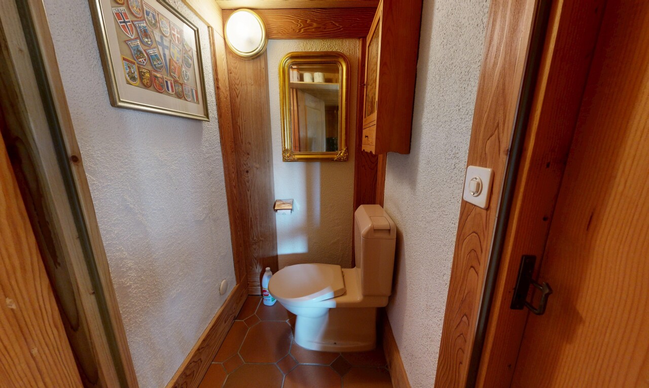 salle de bains avec sol en carrelage, tile floor, toilette, inside property, et mur texturé