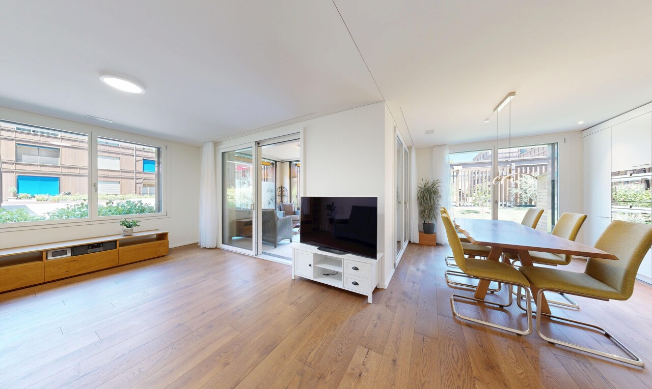 wohn- / esszimmer mit fernseher, holzfußboden, wood finish floor, gipskartonwand, und drywall