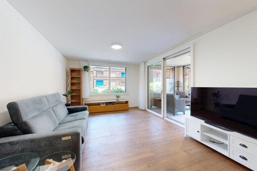 wohnzimmer mit fernseher, gipskartonwand, drywall, holzfußboden, und wood finish floor
