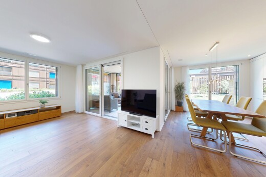 wohn- / esszimmer mit fernseher, holzfußboden, wood finish floor, gipskartonwand, und drywall