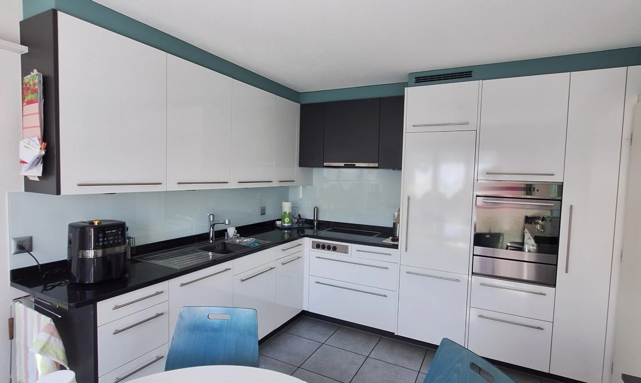kitchen with stainless steel oven, white cabinets, dark countertops, and dark tile patterned floors