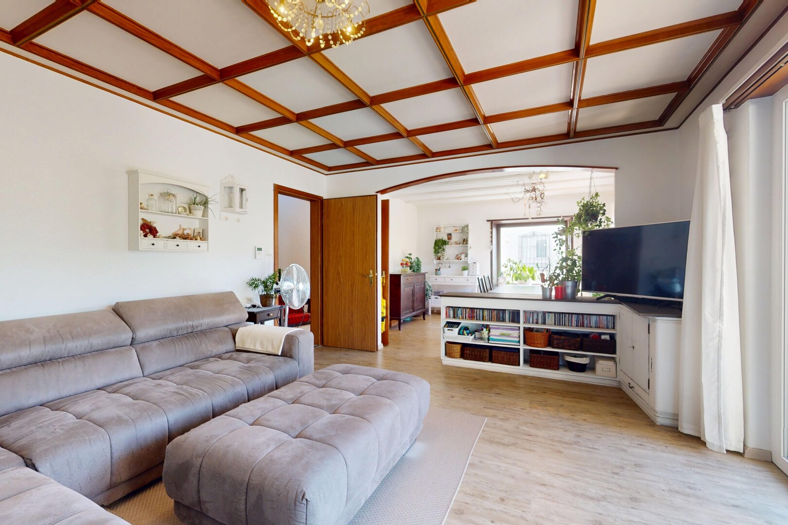 salon avec télévision, lustre remarquable, inside property, natural light, et lumière naturelle
