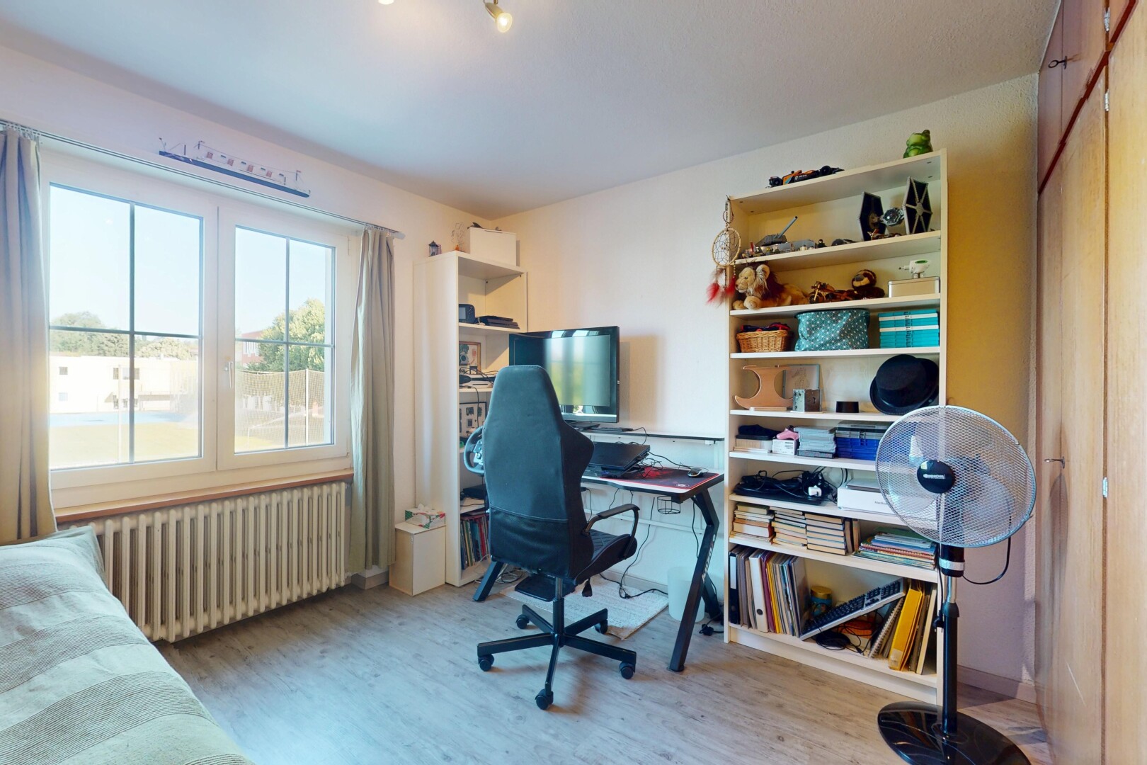 bureau avec télévision, radiateur, sol en finition bois, wood finish floor, et inside property