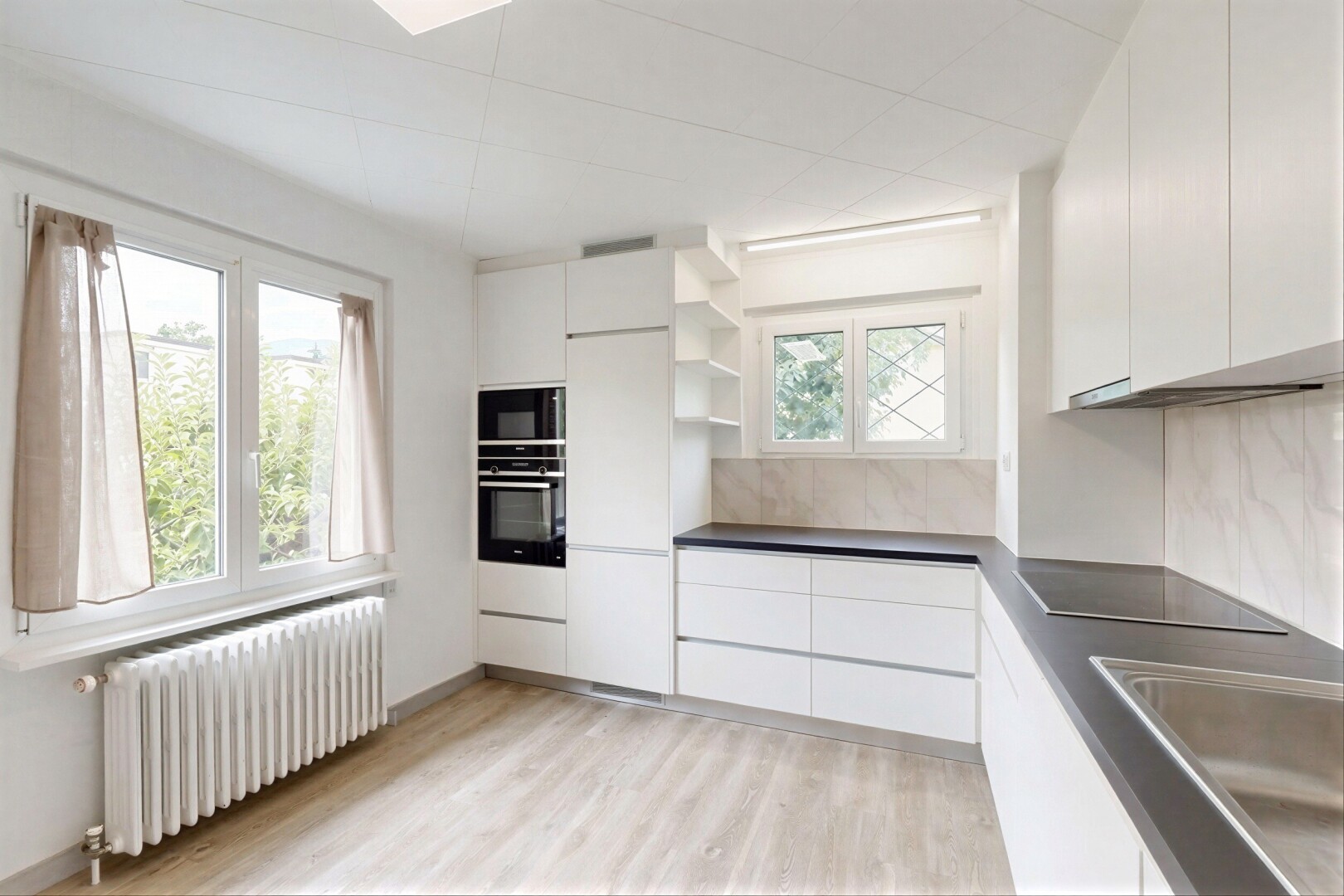 cuisine avec radiateur, open shelves, étagères ouvertes, lumière naturelle, et inside property