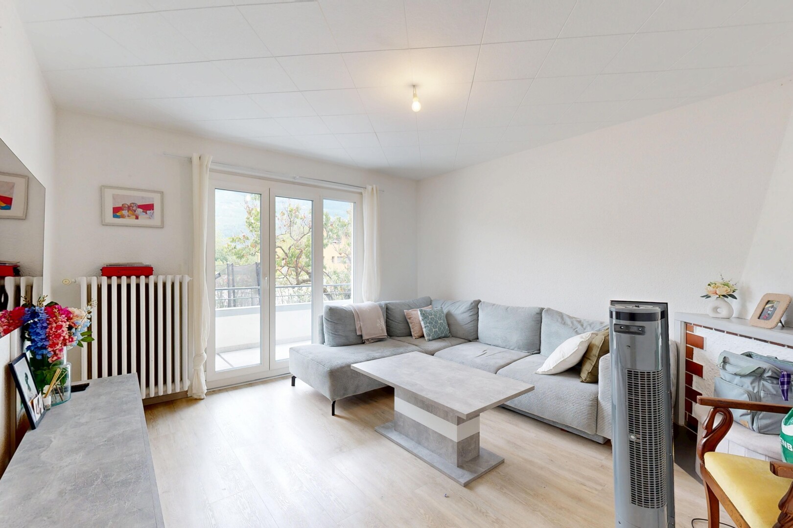 salon avec radiateur, inside property, drywall, cloison sèche, et wood finish floor
