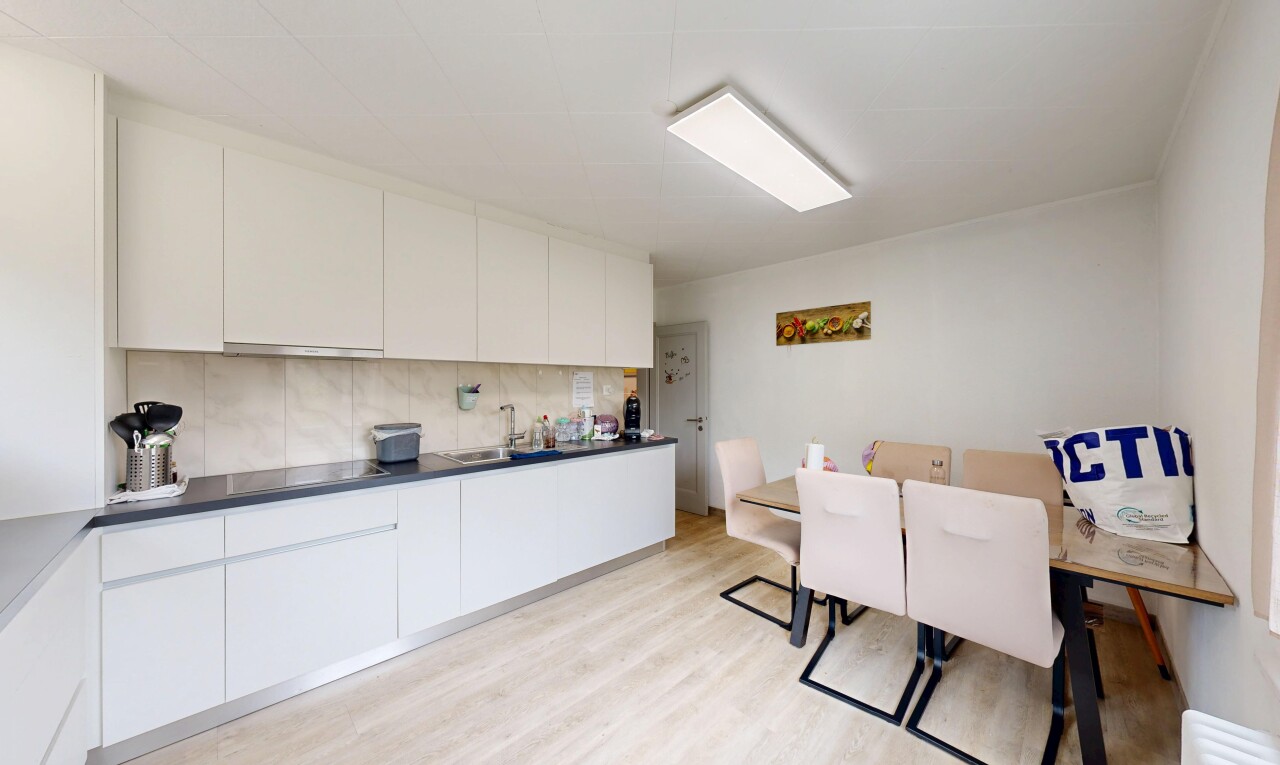 cuisine avec inside property, flat panel cabinets, armoires à panneau plat, light floor, et drywall