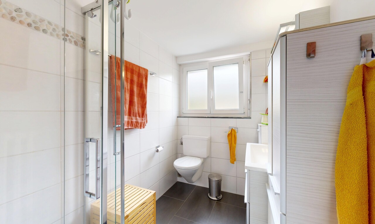 salle de bains avec lumière naturelle, tile wall, mur en carrelage, douche, et lavabo (ou coiffeuse selon le contexte)
