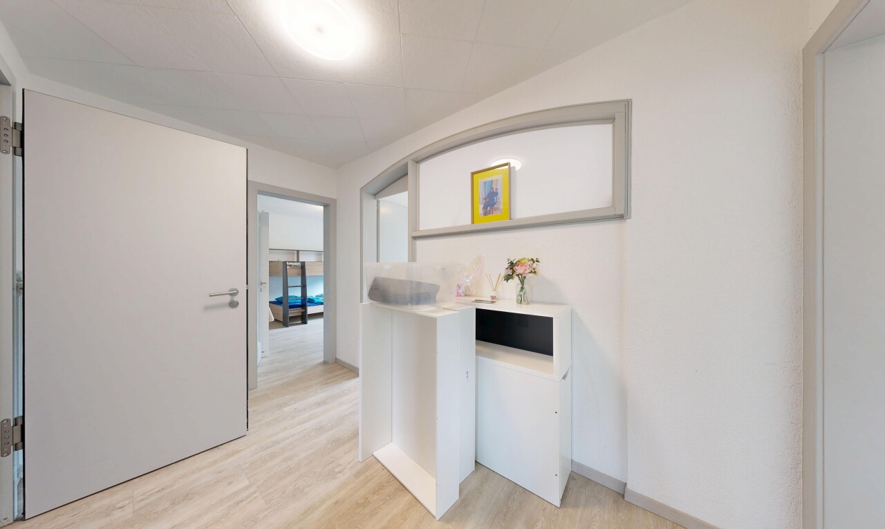 couloir avec inside property, drywall, cloison sèche, wood finish floor, et sol en finition bois