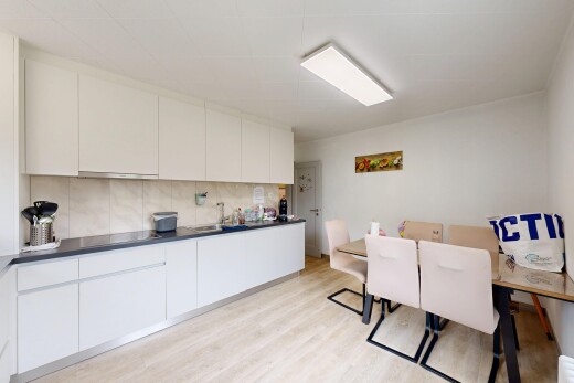 cuisine avec inside property, flat panel cabinets, armoires à panneau plat, light floor, et drywall