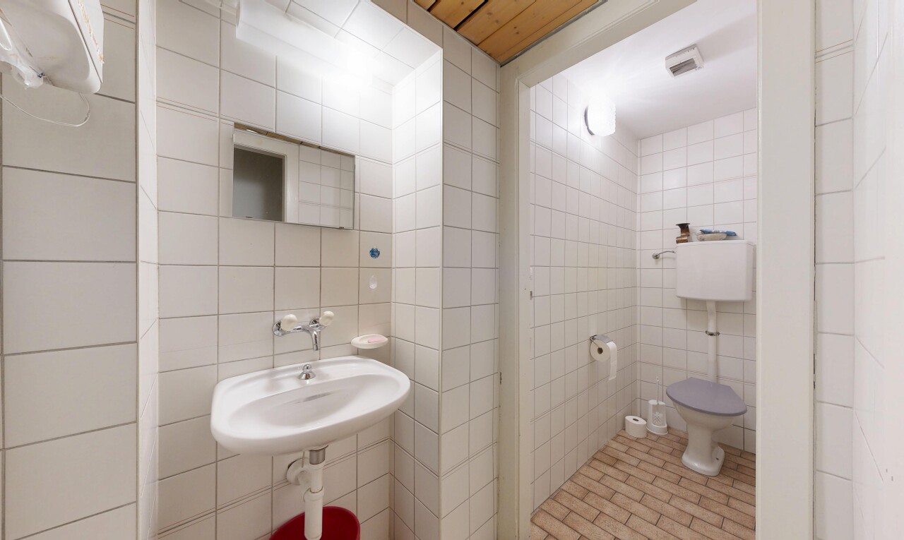 salle de bains avec mur en carrelage, tile wall, miroir, évier, et inside property