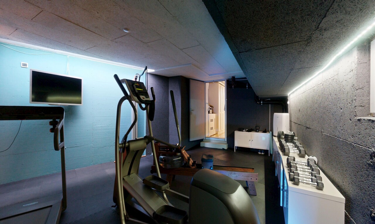 fitnessstudio mit fernseher, keller, inside property, dark floor, und concrete floor