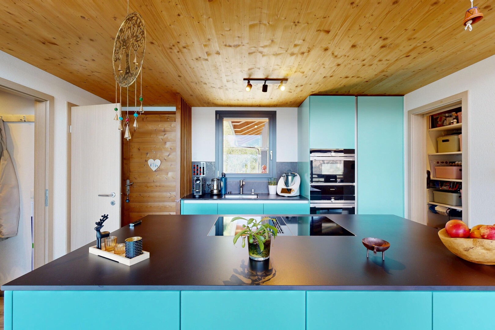 kitchen with blue cabinetry, rail lighting, dark countertops, wood ceiling, and double oven