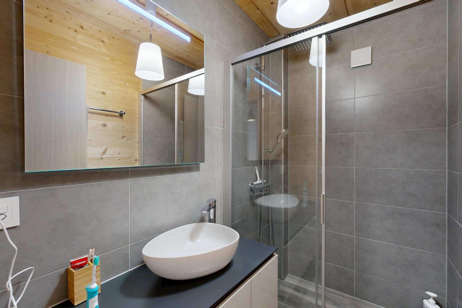 full bath with a shower stall, vanity, and tile walls