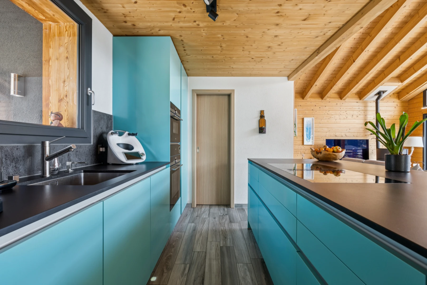 cuisine avec armoires bleues, blue cabinets, plans de travail, dark countertops, et high end ceiling
