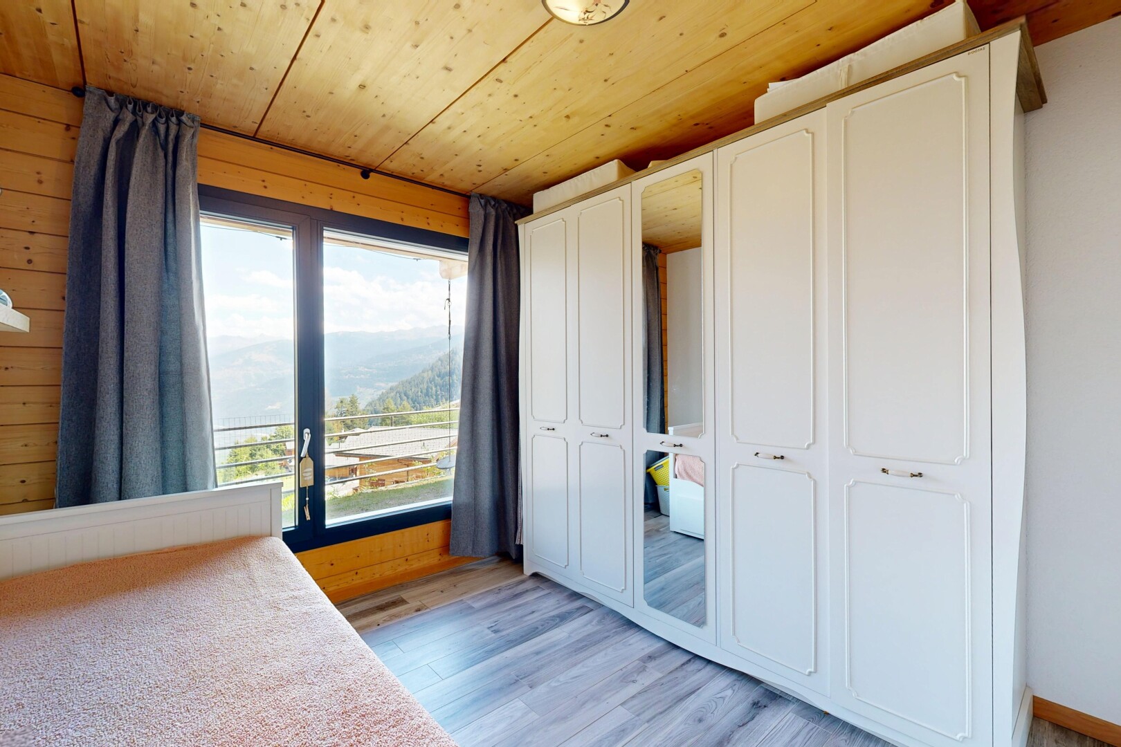 unfurnished room featuring a closet, light wood-style floors, access to exterior, wood ceiling, and wooden walls