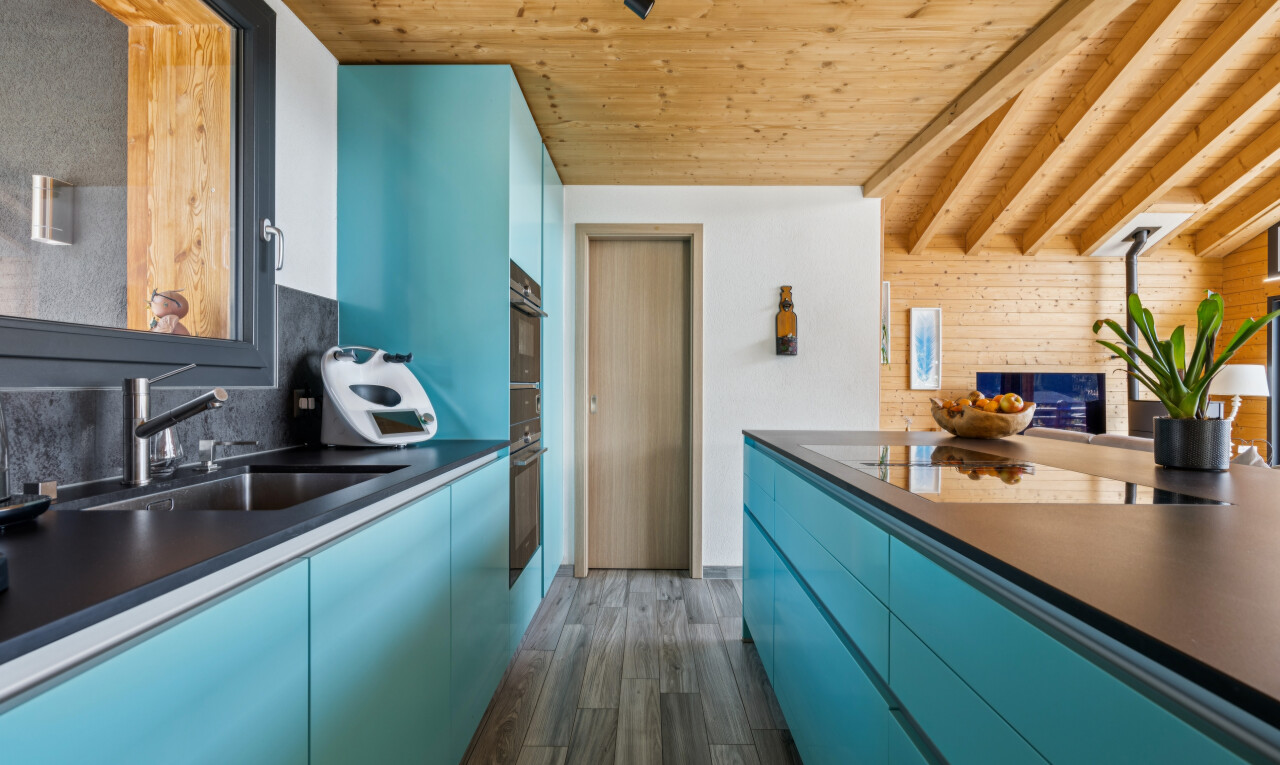 cuisine avec armoires bleues, blue cabinets, plans de travail, dark countertops, et high end ceiling