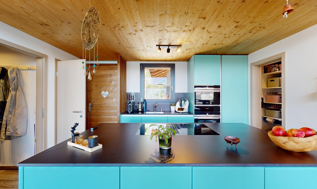 kitchen with blue cabinetry, rail lighting, dark countertops, wood ceiling, and double oven