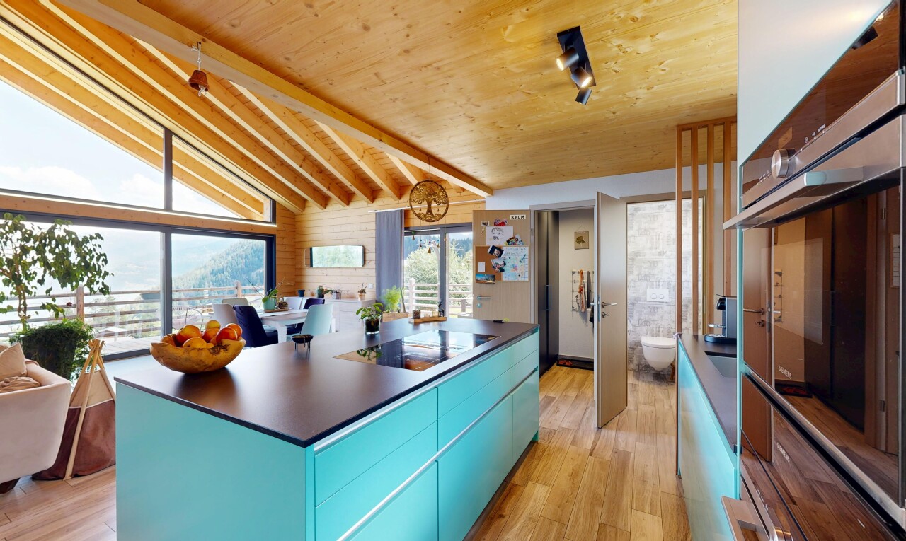 kitchen featuring blue cabinetry, modern cabinets, oven, vaulted ceiling with beams, and dark countertops
