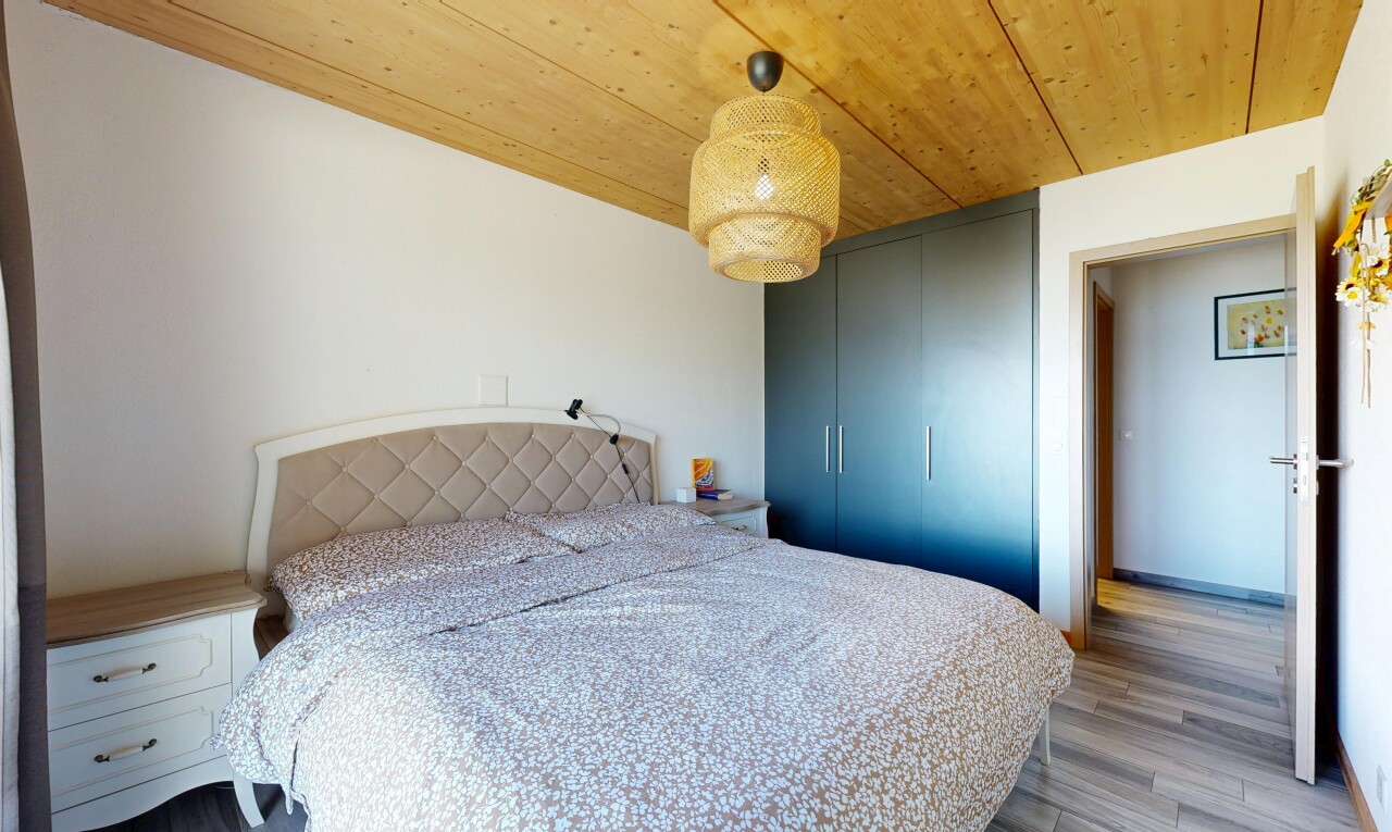 room featuring wooden ceiling, hanging light fixtures, light wood finished floors, and a closet