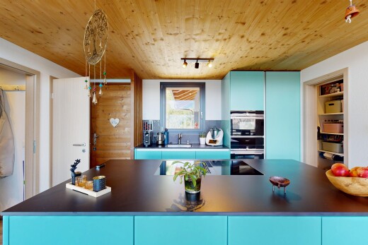 kitchen with blue cabinetry, rail lighting, dark countertops, wood ceiling, and double oven