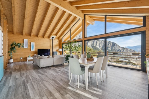 salon / salle à manger avec mur en bois, wood wall, high end ceiling, plafond voûté, et vaulted ceiling