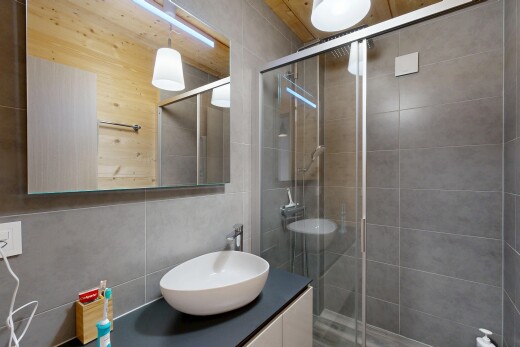 full bath with a shower stall, vanity, and tile walls