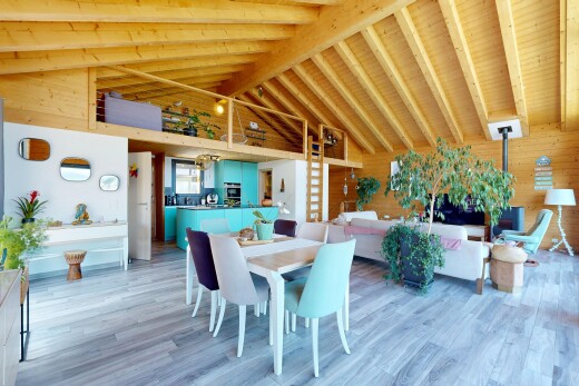 living area featuring light wood-style floors, wood walls, and a high wooden beamed ceiling
