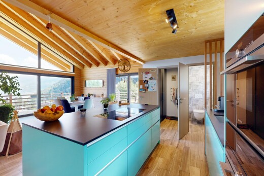 kitchen featuring blue cabinetry, modern cabinets, oven, vaulted ceiling with beams, and dark countertops