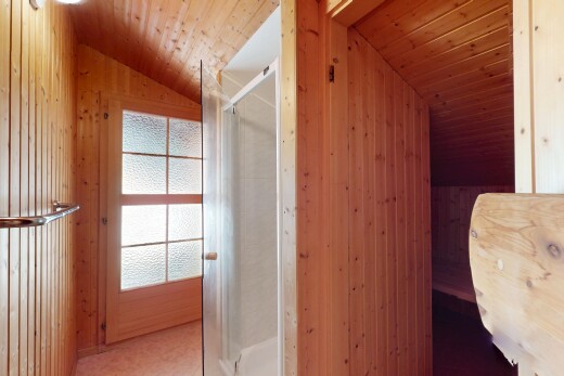 bathroom featuring lofted ceiling, a shower stall, wooden walls, and wood ceiling