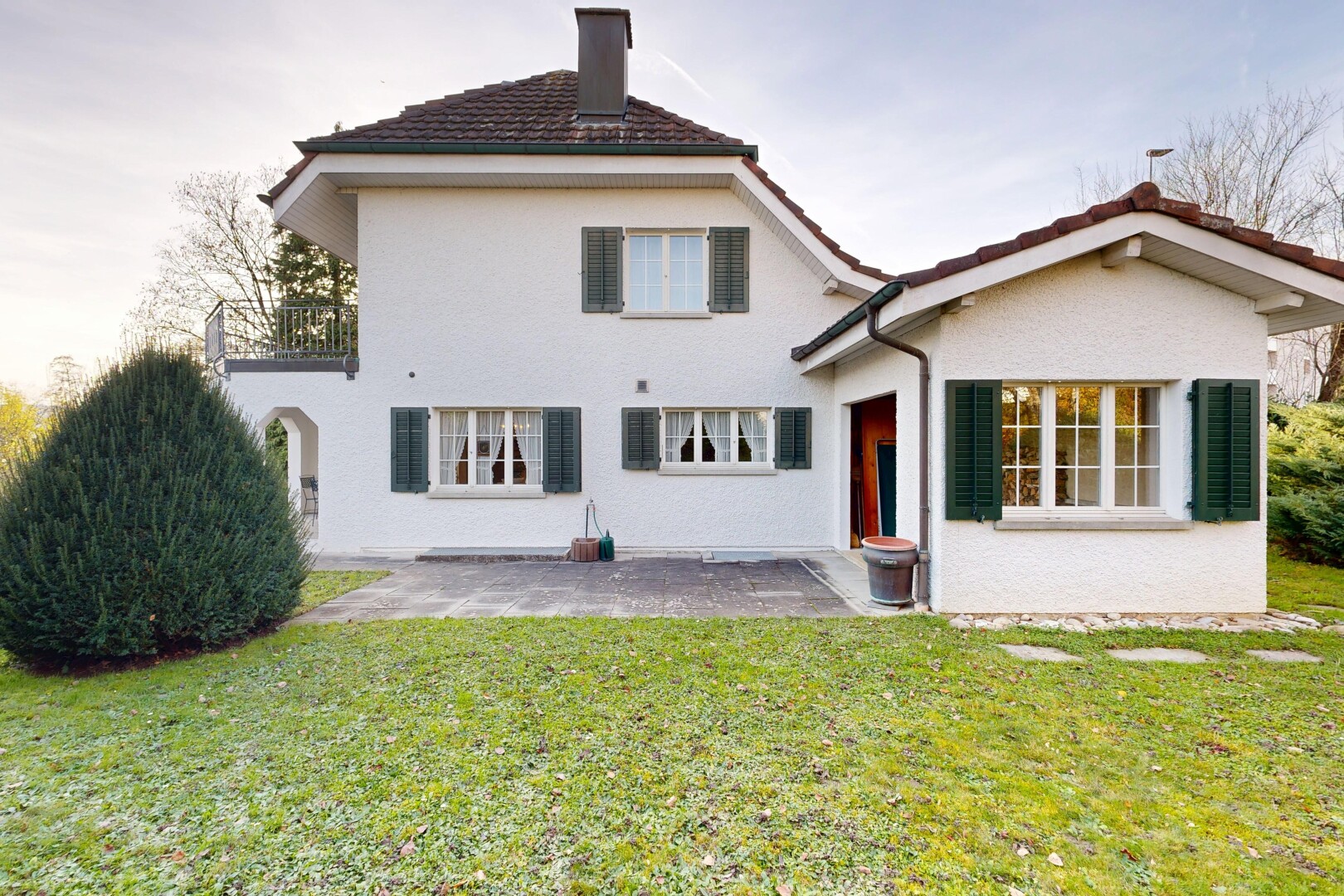 façade avec pelouse, terrasse, property visible, cheminée, et bardage en stuc