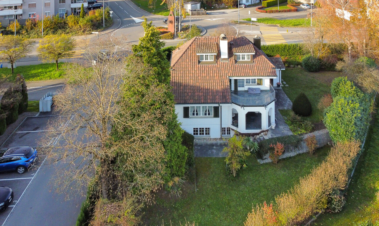façade avec terrasse, property visible, pelouse, toit en tuiles, et parking