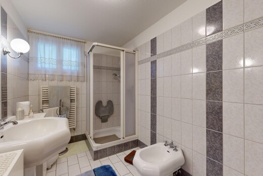 bathroom featuring tile walls, tile patterned floors, a towel warmer, a stall shower, and a bidet