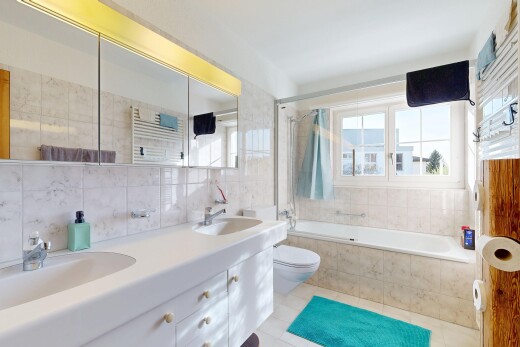 bathroom with tile walls, double vanity, decorative backsplash, light tile patterned floors, and tiled shower / bath combo