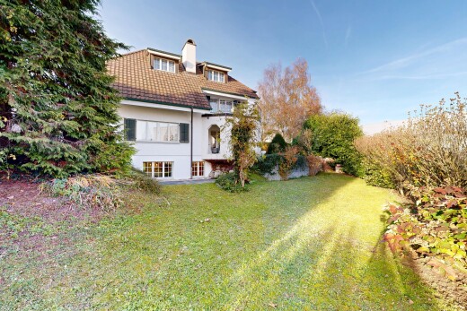 view of home with a lawn, stucco siding, a chimney, a balcony, and a patio area