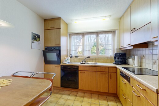 kitchen with backsplash, light countertops, black appliances, and light tile patterned flooring