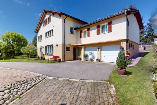 view of home featuring asphalt driveway, a garage, stucco siding, and a lawn