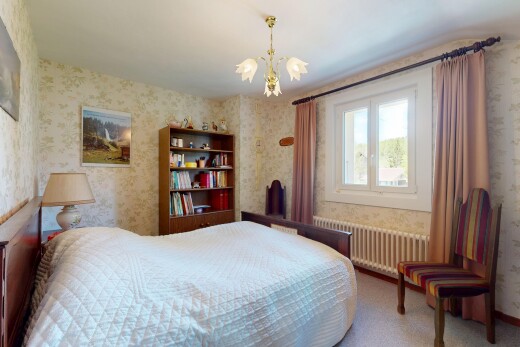 carpeted room with radiator, wallpapered walls, and a chandelier