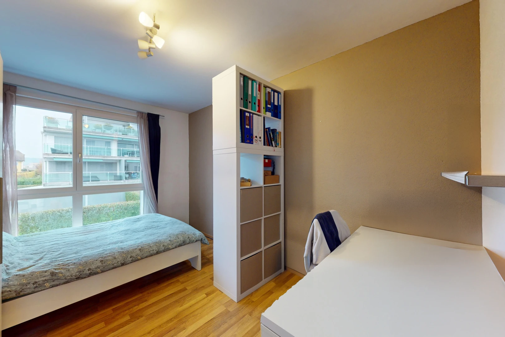chambre avec lumière naturelle et plancher de bois