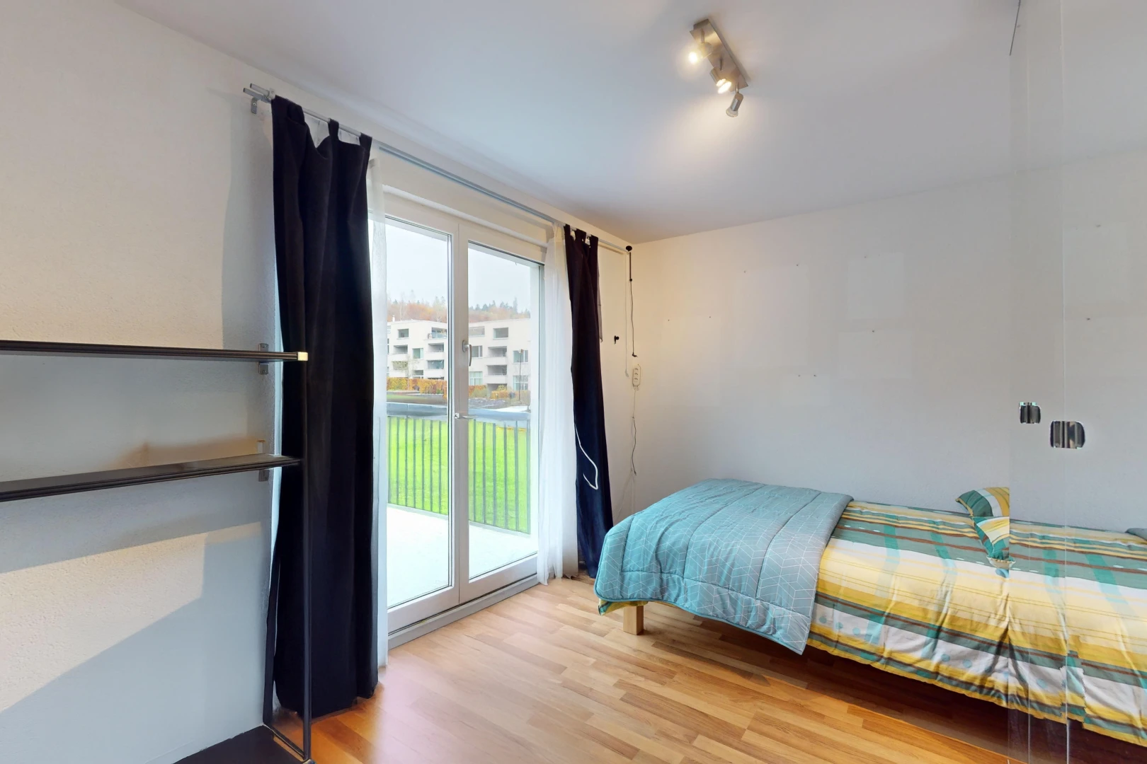 chambre avec plancher de bois, lumière naturelle, et accès à l'extérieur