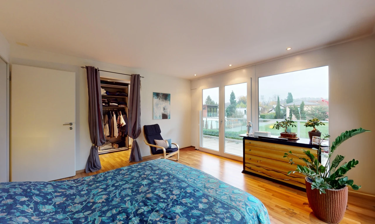 chambre avec plancher de bois, lumière naturelle, et accès à l'extérieur