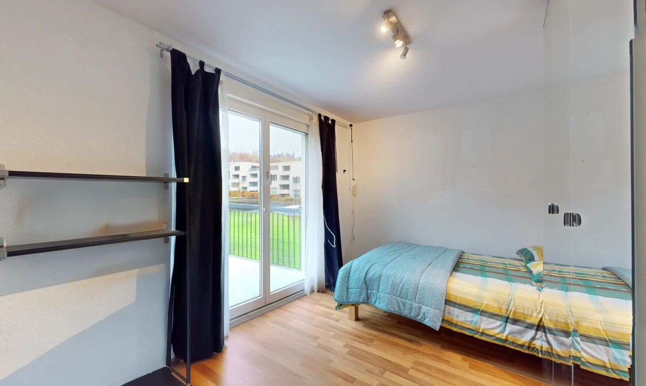 chambre avec plancher de bois, lumière naturelle, et accès à l'extérieur