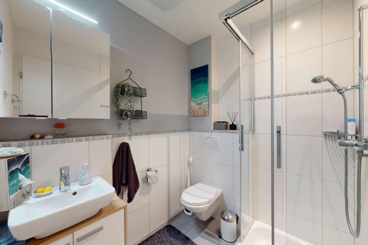 salle de bains avec mur carrelé, vasque, meuble-lavabo, miroir, et douche